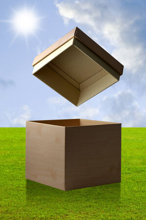 Open paper box with nice green field backgroundの写真素材