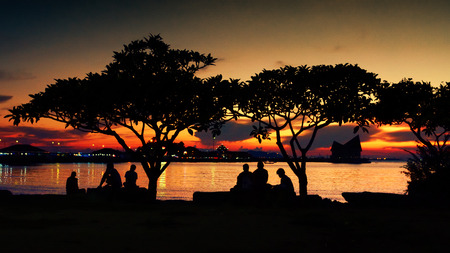 Silhouette of people rest in park with sunset sky background at seasideの写真素材