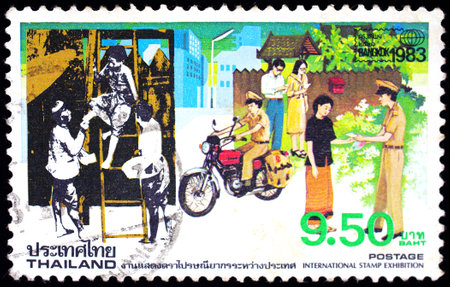 THAILAND - CIRCA 1983: A stamp printed in Thailand shows image of postman working, To commemorate International Stamp Exhibition, circa 1983のeditorial素材