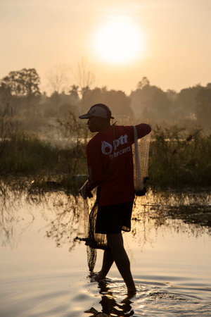 Villager carry the net on November 21, 2014 in Bang Pra reservoir, Chonburi, Thailand