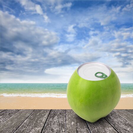 Fresh coconut with can open tool on top and sea backgroundの写真素材