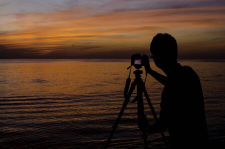Photographer take photo of sunset sky at seaの写真素材