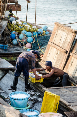 CHONBURI, THAILAND - MAR 4 :  Unidentified worker carry fish basket to jetty on 4 March, 2015 in Chonburi, Thailandのeditorial素材