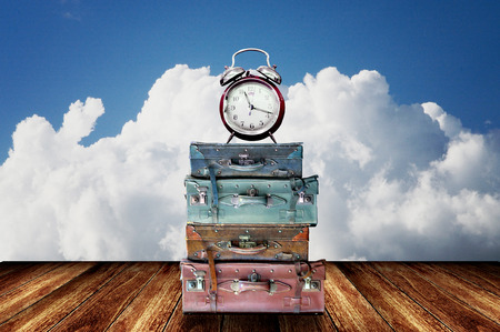 Time to travel concept, Baggage and alarm clock on wooden floor