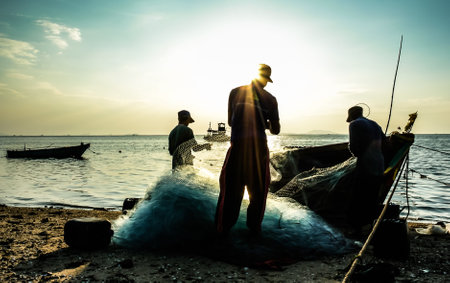 CHONBURI, THAILAND - DEC 9 : Group of fishermen clear fish from net on 9 December 2016 in Bangpra, Sriracha, Chonburi, Thailandのeditorial素材