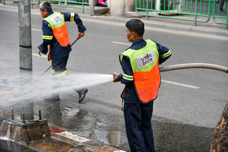 BANGKOK, THAILAND - 15 DEC : District staff worker cleaning footpath on 15 December 2018 in Silon road, Bangkok, Thailandのeditorial素材