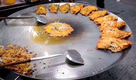 Big hot pan with green mussel fried with crispy fried egg , Thai street foodの写真素材