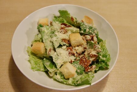 Caesar Salad in bowl on wooden tabaleの写真素材