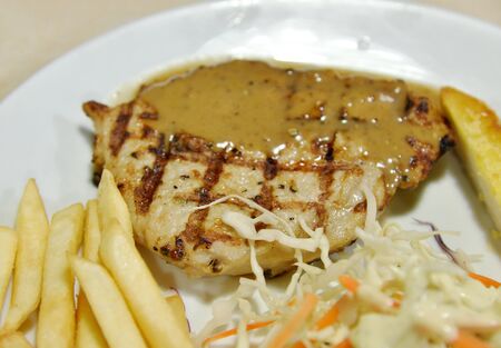 Pork steak close up shot with potato fried and saladの写真素材