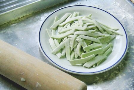 Prepare a fresh homemade pasta in dish with rolling pin beside