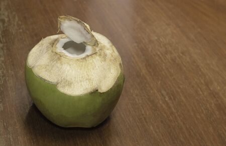 Coconut fruit opened on wooden table backgroundの写真素材