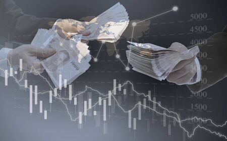 Investment and business background, Banknote in hand with stock market graphs technologyの写真素材