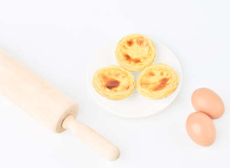 Egg tarts, eggs and other ingredients and tools on white  backgroundの写真素材