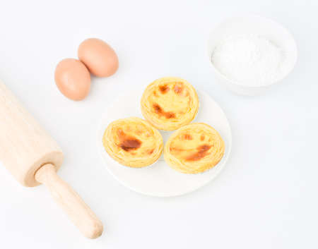 Egg tarts, eggs and other ingredients and tools on white  backgroundの写真素材