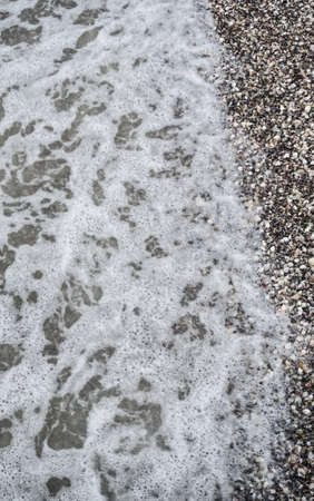 Sea surf and foam at beach with seashell backgroundの写真素材