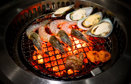 Raw shrimp and seashell at grill on stove for BBQの写真素材