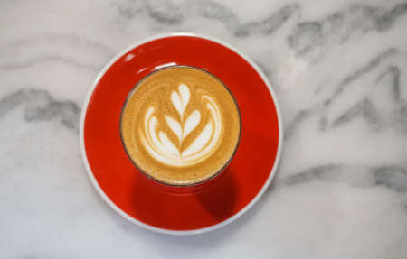 Latte art with red dish on marble table , Top viewの写真素材