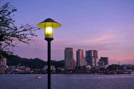 Street lamp post with cityscape and twilight sky backgroundの写真素材
