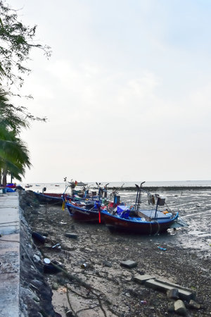 CHONBURI, THAILAND - 14 MARCH : Fisherman boat moor at port with low tide sea on 14 March 2022 in Bangphra, Siracha, Chonburi, Thailandのeditorial素材