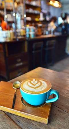 Close up shot of latte coffee cup on wooden table, Cafe backgroundの写真素材