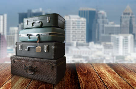 Vintage travel bag on wooden floor with cityscape backgroundの写真素材
