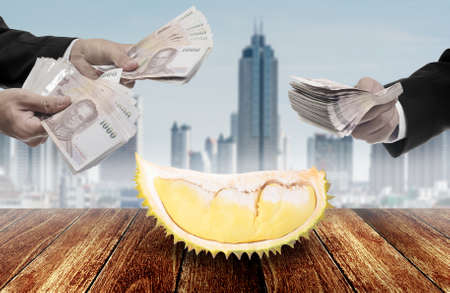 Businessman offer money for Durian tropical fruit on deck, High demand conceptの写真素材