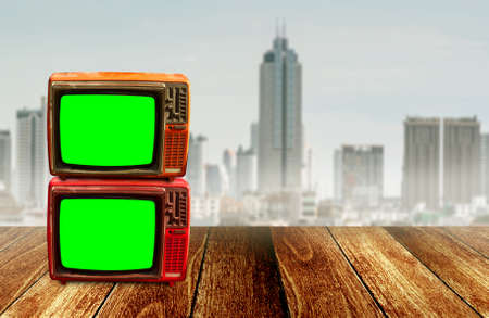 Group of television with green screen on wooden floor with cityscape blurred backgroundの写真素材
