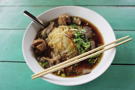 Noodles with stewed pork soup on green table background