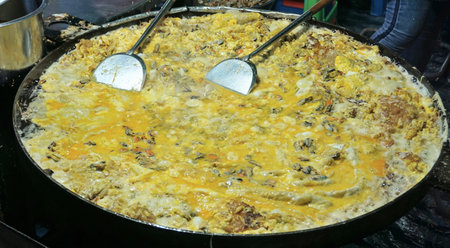 Thai food, Omelet with green mussel fried in big hot pan for crispy fried mussel pancakeの写真素材