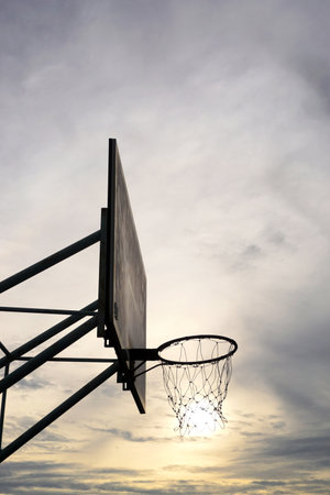 Basketball hoop with sunset sky backgroundの写真素材
