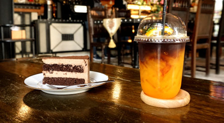 Cake with orange coffee in cafeの写真素材
