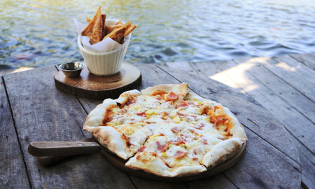 Hot pizza at deck with lake backgroundの写真素材