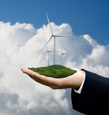 Green energy concept, Wind turbine in business hand with clouds sky backgroundの写真素材