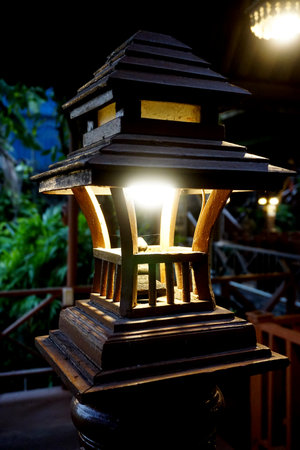 Wooden lantern in Thai style with light bulb at  balusterの写真素材