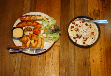 Spaghetti carbonara with German sausage on wooden tableの写真素材