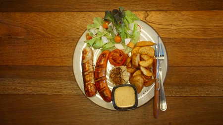 German sausage grilled with salad and potato chips, Top viewの写真素材