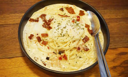 Spaghetti carbonara with becon on wooden tableの写真素材