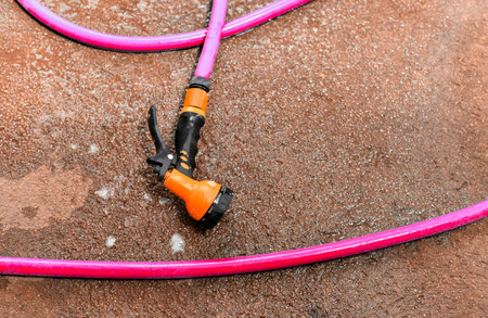 Water spay gun and pipe on wet ground, Washing toolの写真素材