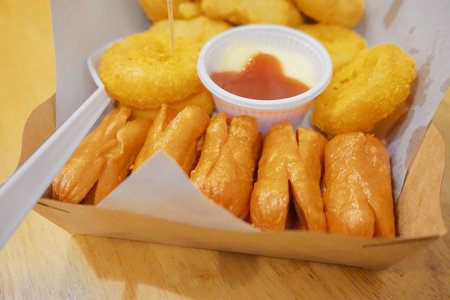 Deep fried snack with sauce, french fries and sausageの写真素材