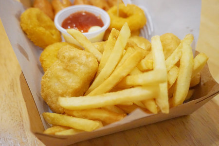 Deep fried snack with sauce, french fries and sausageの写真素材