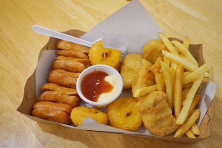 Deep fried snack with sauce, french fries and sausageの写真素材