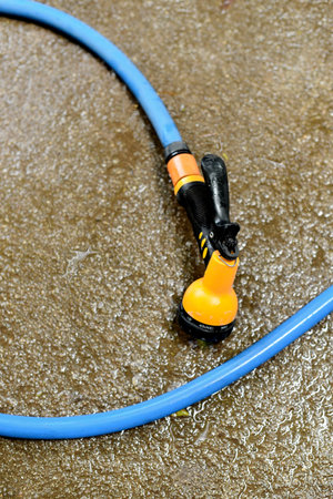 Water spay gun and pipe on wet ground, Washing toolの写真素材