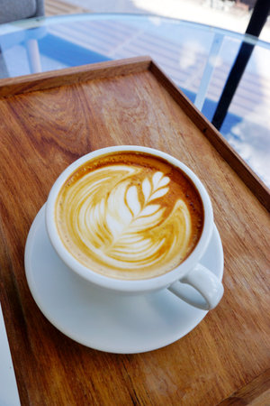 Latte coffee on wooden trayの写真素材
