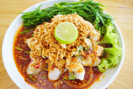 Oyster salad with spice sauce and fried garlic and fresh young Acacia Leaves, Thai seafood cuisineの写真素材