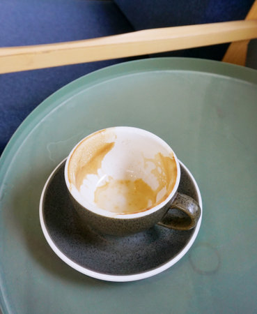 Empty coffee cup on table with chair beside, Rest at cafeの写真素材