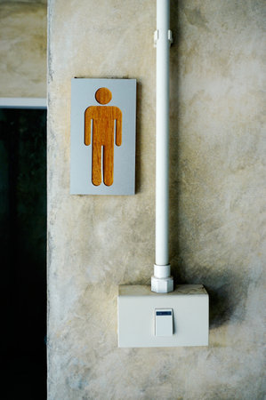 Men toilet sign at wall with switch