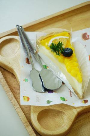 Close up shot of mango fruit cake decorate with orange and blueberryの写真素材