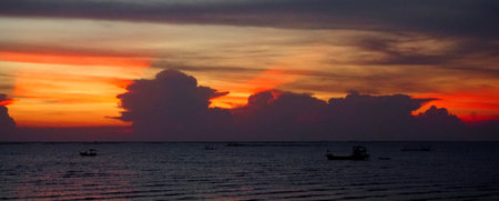 Sunset ray shine through clouds with sea and sky backgroundの写真素材
