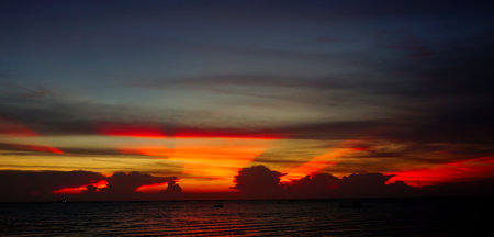 Sunset ray shine through clouds with sea and sky backgroundの写真素材