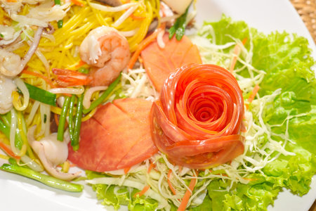 Tomato decorate on Chinese-styled fried noodle close up shot